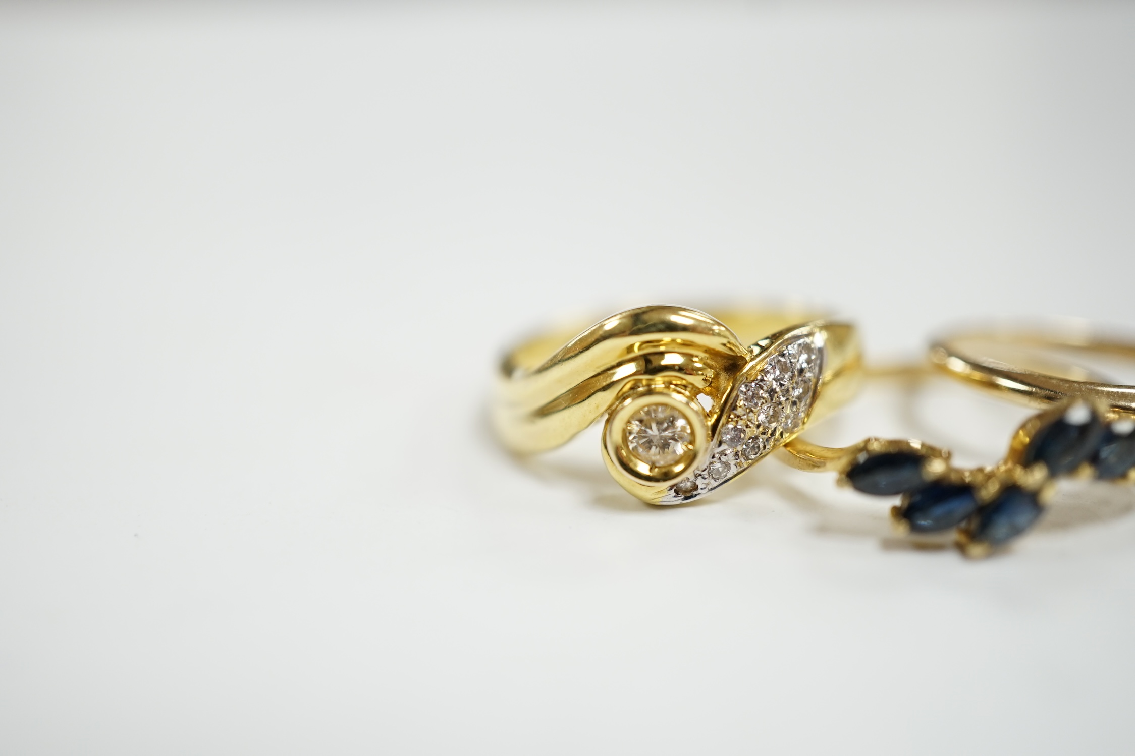 Three assorted modern 14k and gem set rings, including single stone marquise cut diamond, diamond chip set and sapphire set, gross weight 7.7 grams.